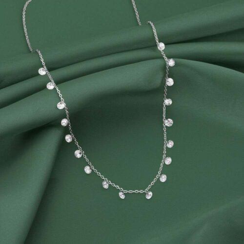 Elegant silver queen necklace displayed on green silk fabric