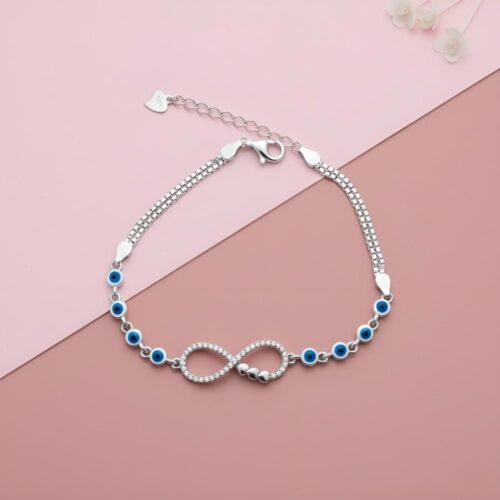 Silver Infinity Bracelet with Blue Evil Eye Charms pink surface
