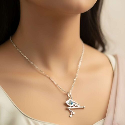 Woman wearing silver Krishna flute pendant necklace with peacock leaf in elegant style