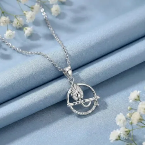 Elegant Silver Krishna Murli Pendant placed on a light blue silk fabric with delicate white flowers