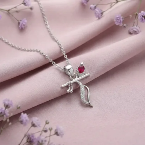 Elegant Silver Krishna flute pendant resting beautifully on soft pink fabric surrounded by delicate floral details.