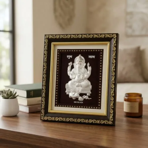 Pure silver ganesh idol frame for home mandir placed beautifully on a wooden table