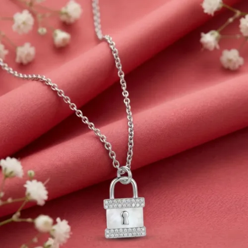 A beautifully styled Mother of Pearl Padlock Necklace resting elegantly on soft red fabric with delicate white flowers
