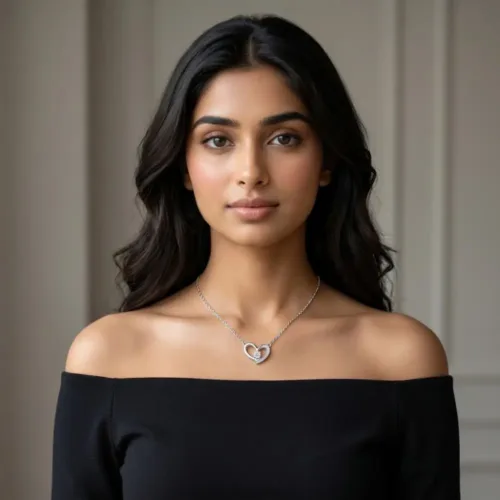 Elegant Indian woman wearing the sterling silver heart pendant with chain paired with an off-shoulder black dress