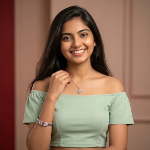 Smiling Indian woman wearing the silver american diamond necklace paired with a light green off-shoulder top