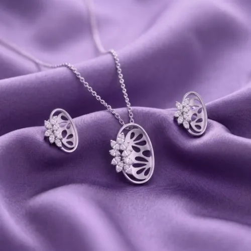 Close up view of the elegant floral silver pendant set resting beautifully on a luxurious purple silk fabric