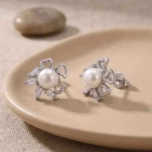 Beautifully displayed floral pearl cz stud earrings 925 resting on an earthy ceramic plate, showcasing their unique half-and-half design.