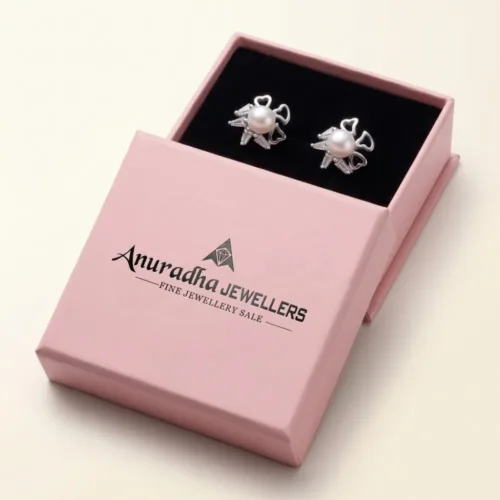 The premium silver pearl starburst stud earrings elegantly presented inside the signature pink Anuradha Jewellers gift box, perfectly arranged on a black velvet tray.