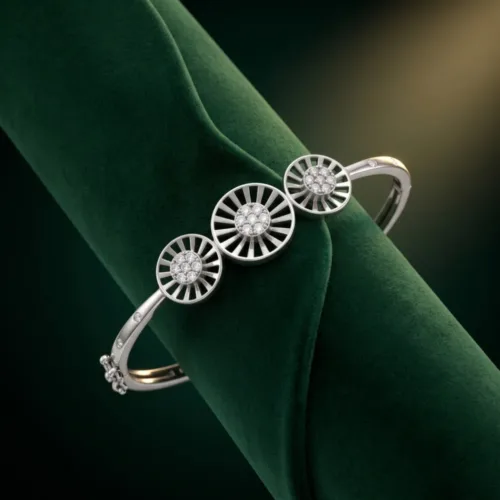 Premium cluster stone silver bangle beautifully displayed on a rich green velvet prop, emphasizing the brilliant sparkling centers of the medallions.