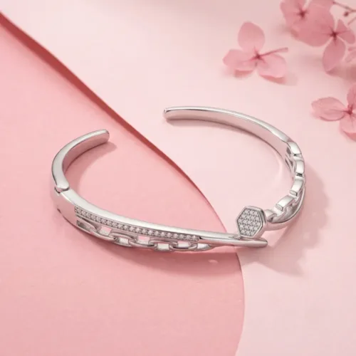 Close-up studio view of the layered chain link cuff bracelet silver displayed on a soft pink background, emphasizing the flexible chain detail integrated with the solid metal.