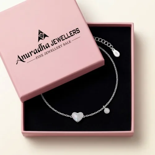Mother of pearl silver heart bracelet securely placed inside a signature pink Anuradha Jewellers gift box on black velvet, ready for gifting.