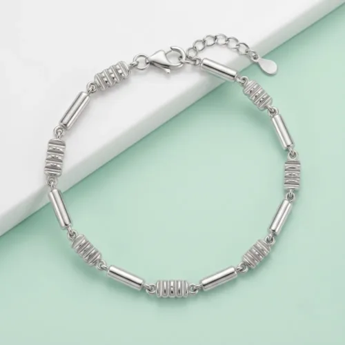 Premium 925 sterling silver link bracelet with a sleek, stone-free design displayed on a modern mint green and white geometric background.