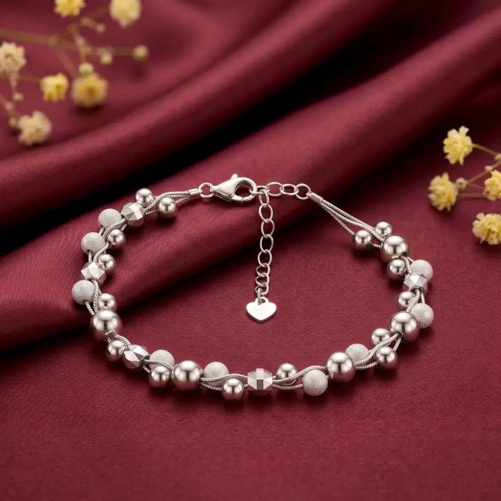 Silver Beaded Bracelet on Silk Elegant multi-strand silver beaded bracelet displayed on a rich maroon silk background, highlighting its unique stone-free design.