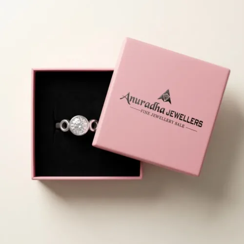 The premium silver bezel set solitaire ring beautifully presented inside the signature pink Anuradha Jewellers gift box on a soft black velvet cushion.