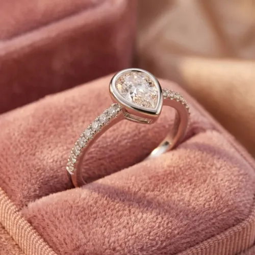 The beautiful teardrop american diamond ring beautifully displayed inside a plush pink velvet box, highlighting the sparkling side stones and smooth, snag-free setting.